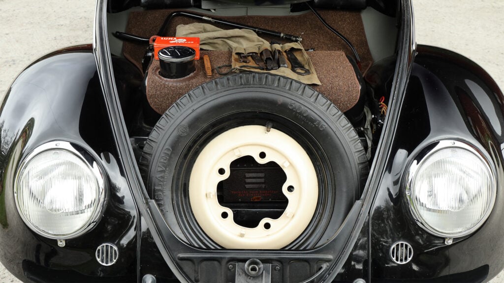 Bagagerummet rymmer både reservhjulet med däck från Gislaved, originalverktyg, startvev, en tank med rejäl stos för att förenkla fältmässigt tankande, samt möjligen också några mindre väskor eller kassar. 